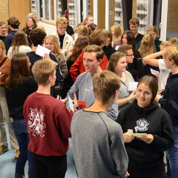 Danske og sydslesvigske elever står og snakker sammen under et besøg af Elevambassadørerne på en skole i Danmark.