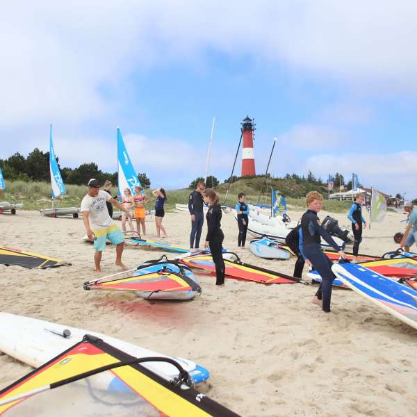 Unge gør klar til windsurfing på stranden på vandrehjemmet i Hørnum på Sild